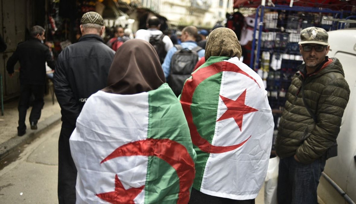 جزائريون خلال تظاهرة مناهضة للحكومة في الجزائر العاصمة (2 آذار 2021، أ ف ب). 