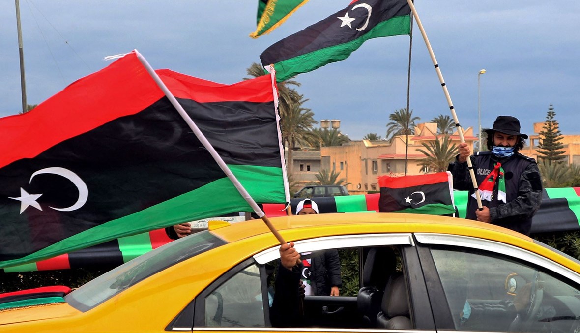 ليبيون في وسط العاصمة طرابلس يحملون أعلام بلادهم (أ ف ب).