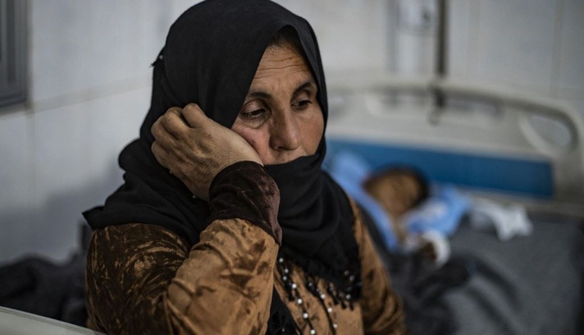 سورية تجلس الى جانب ابنتها المصابة بحروق في مستشفى بالحسكة بشمال شرق سوريا. (أ ف ب)