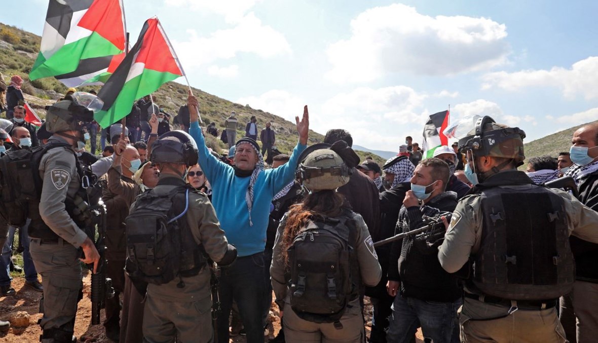 متظاهرون فلسطينيون في مواجهة قوات اسرائيلية خلال احتجاج على المستوطنات اليهودية في قرية بيت دجان بالقرب من نابلس شمال الضفة الغربية المحتلة (5 آذار 2021، أ ف ب). 