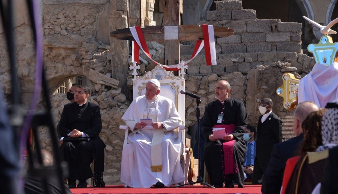 البابا فرنسيس-في الوسط- أمام أنقاض كنيسة الطاهرة الكبرى للسريان الكاثوليك في الموصل أمس.   (أ ف ب)