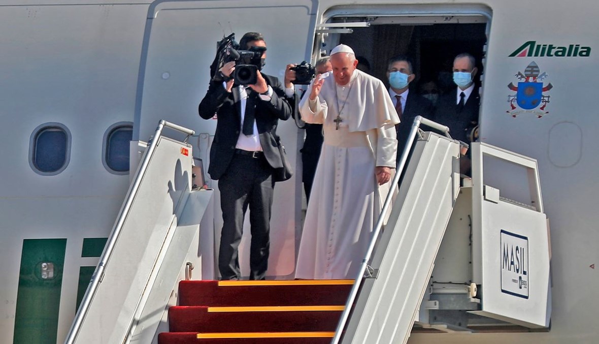 البابا فرنسيس مودعا مضيفيه العراقيين عند باب الطائرة، قبل مغادرة بغداد (8 آذار 2021، أ ف ب).