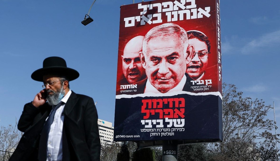 رجل يهودي متشدد يمر بالقرب من لوحة إعلانية كبيرة تصور نتنياهو في القدس (10 آذار 2021، أ ف ب). 