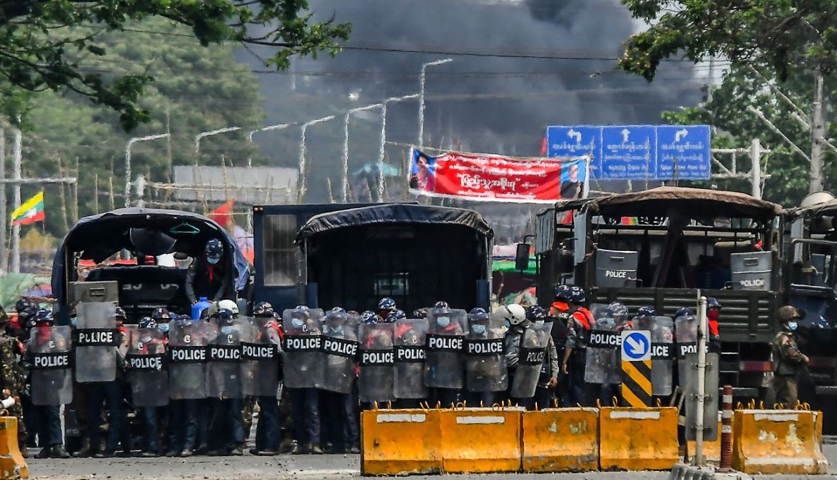 قوات الأمن تشكل حاجزا في مواجهة متظاهرين في يانغون (14 آذار 2021، أ ف ب). 