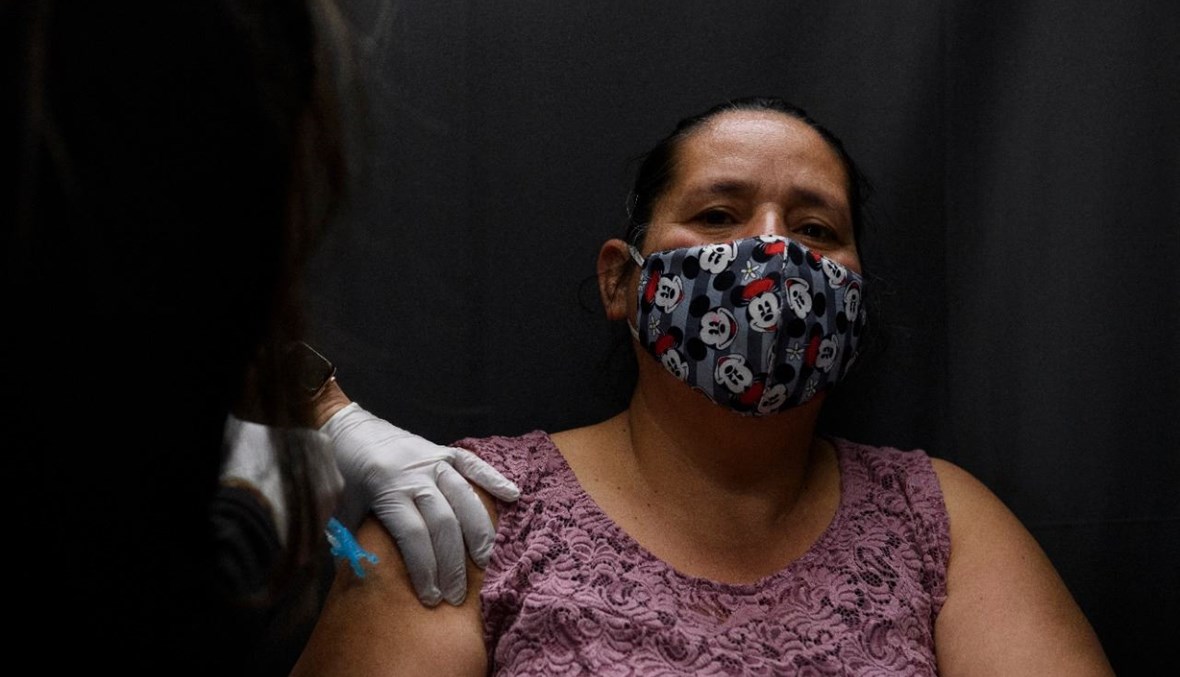 امرأة تتلقى لقاح  كورونا في مركز للتطعيم في ديلانو بكاليفورنيا (13 آذار 2021، أ ف ب). 