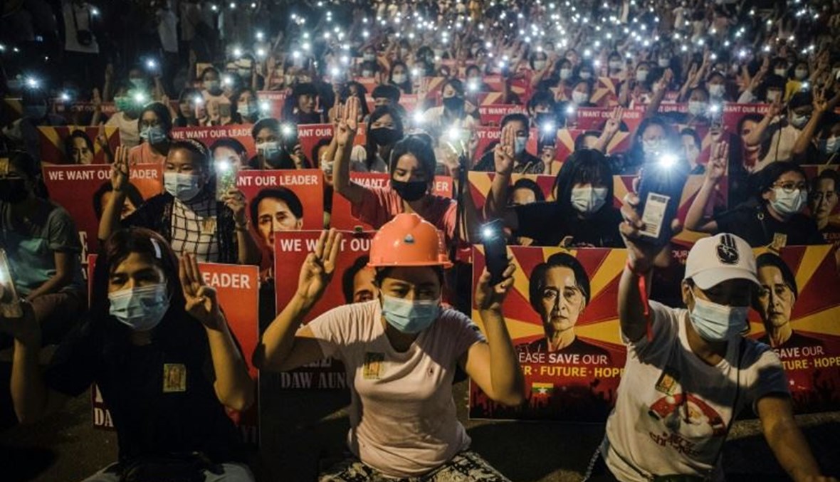 محتجون في ميانمار يؤدون التحية بالأصابع الثلاث المميزة للاحتجاجات ويرفعون لافتات تحمل صور الزعيمة المدنية أونغ سان سو تشي، خلال احتجاج ضد الانقلاب العسكري في رانغون    الجمعة.   (أ ف ب)