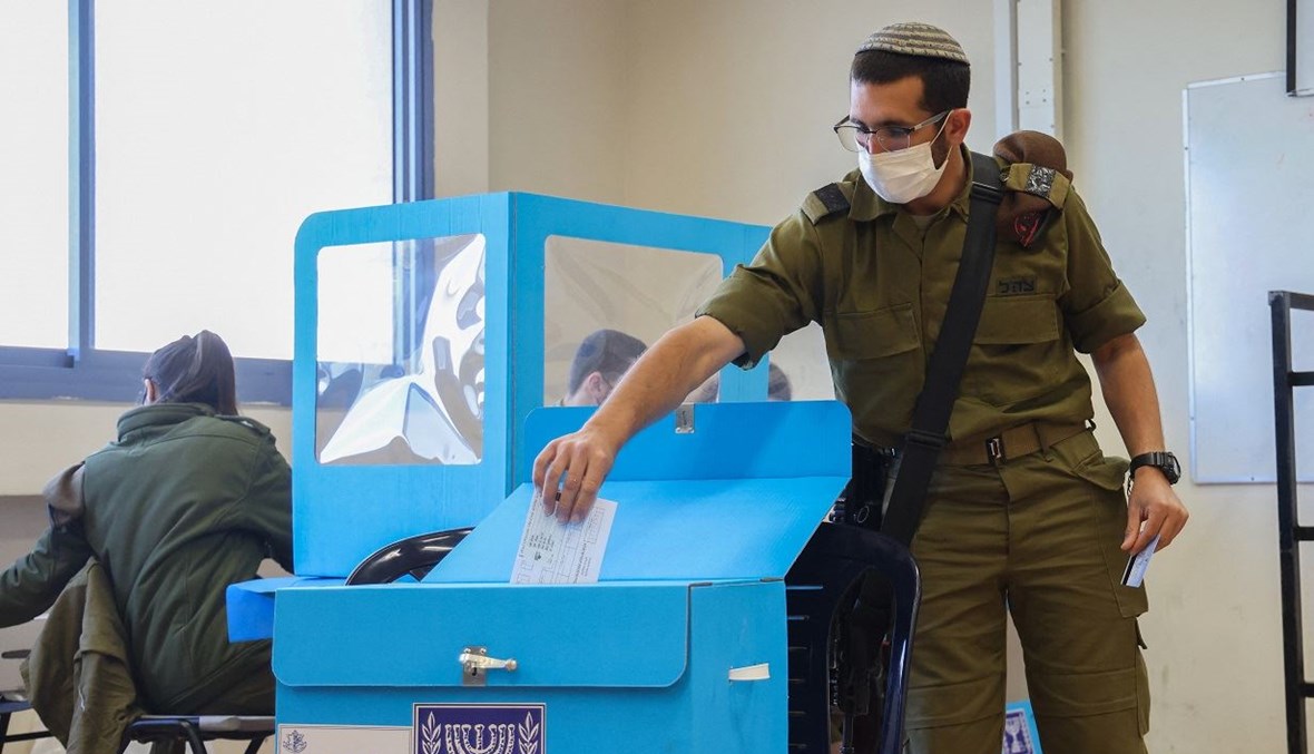 جندي إسرائيلي يدلي بصوته خلال الانتخابات البرلمانية المبكرة (أ ف ب).