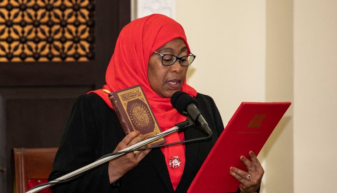 حسن تحمل القرآن خلال مراسم أداء اليمين كأول رئيسة لتنزانيا، في قصر الدولة في دار السلام (19 آذار 2021، أ ف ب). 