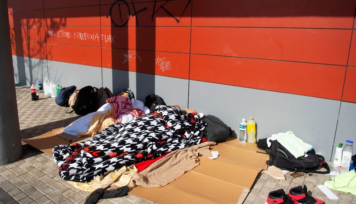 مهاجرون نائمون على رصيف في مدينة إيرون الباسكية الإسبانية (10 آذار 2021، أ ف ب). 