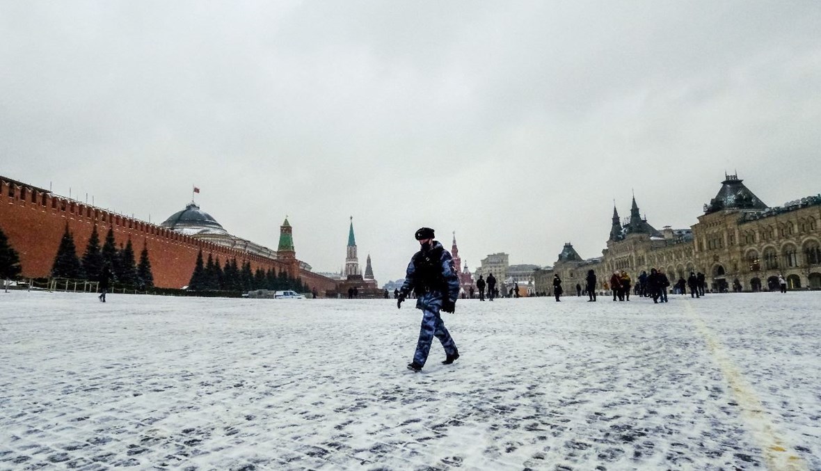 شرطي يعبر الساحة الحمراء في موسكو، وسط الثلوج (13 آذار 2021، أ ف ب).  