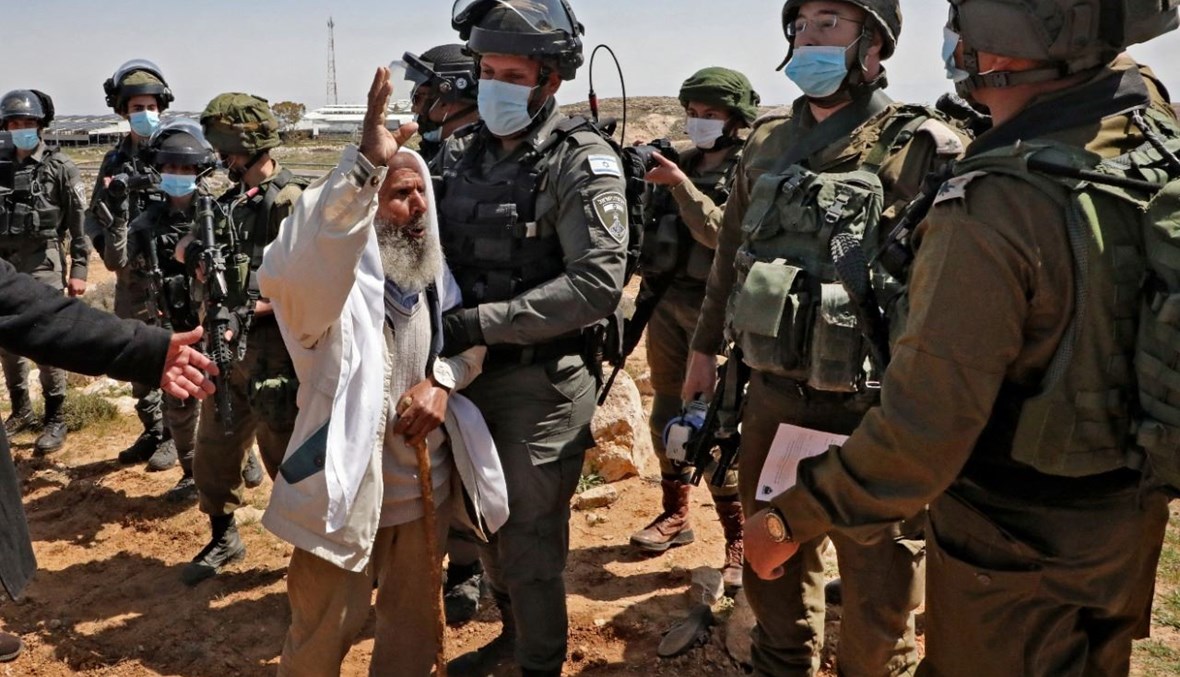 رجل فلسطيني مسن خلال تظاهرة احتجاجية على مصادرة الأراضي لصالح مستوطنة كرمل الإسرائيلية، بالقرب من قرية يطا جنوب الخليل في الضفة الغربية المحتلة (19 آذار 2021، أ ف ب). 