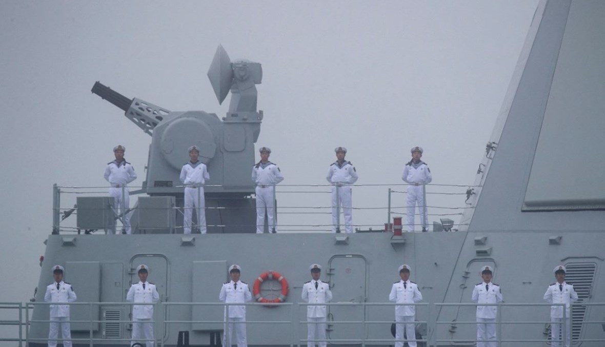 بحارة صينيون يقفون على متن مدمرة خلال المشاركة في عرض بحري بالقرب من مدينة تشينغداو بمقاطعة شاندونغ شرق الصين، لإحياء الذكرى الـ70 لتأسيس البحرية الصينية (23 نيسان 2019، أ ف ب). 
