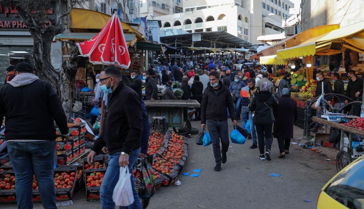 عشرات الفلسطينيين يتسوقون في سوق في مدينة رام الله بالضفة الغربية (18 آذار 2021، أ ف ب). 