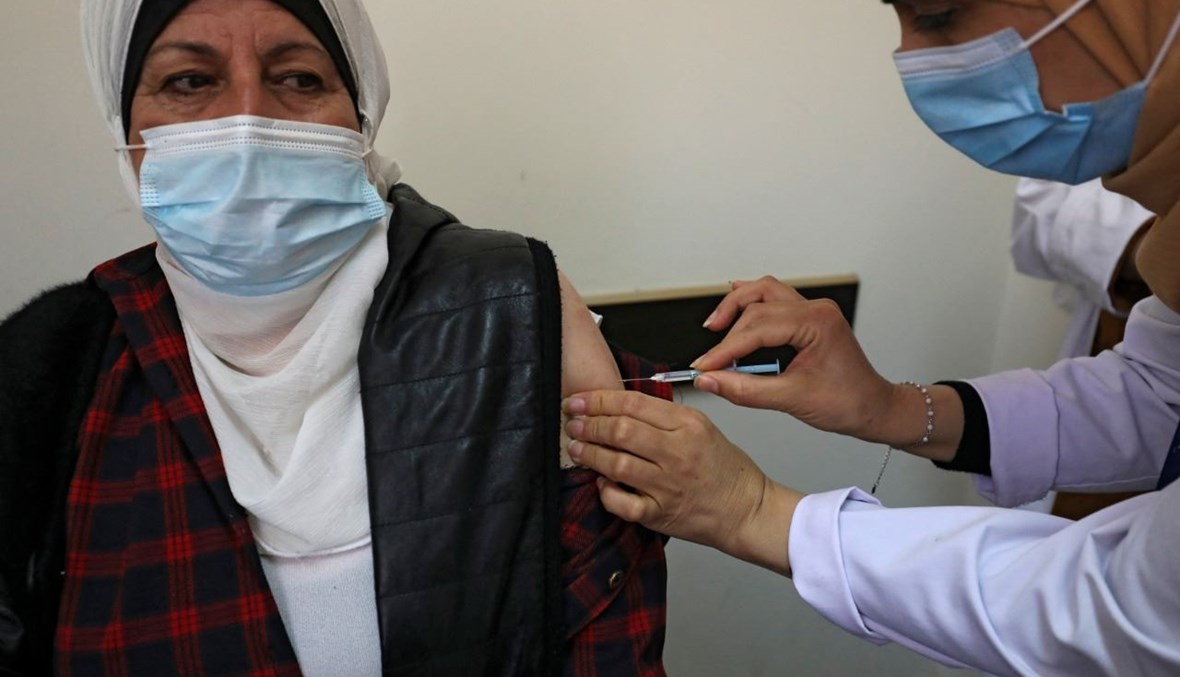 امرأة تتلقى لقاح كورونا في مستشفى برام الله بالضفة الغربية (21 آذار 2021، أ ف ب). 