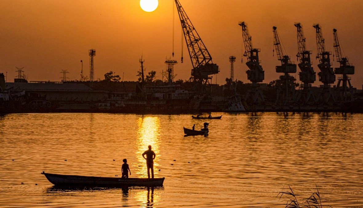 صياد يقف في زورق في نهر شط العرب بميناء المعقل في مدينة البصرة جنوب العراق (21 آذار 2021، ا ف ب). 