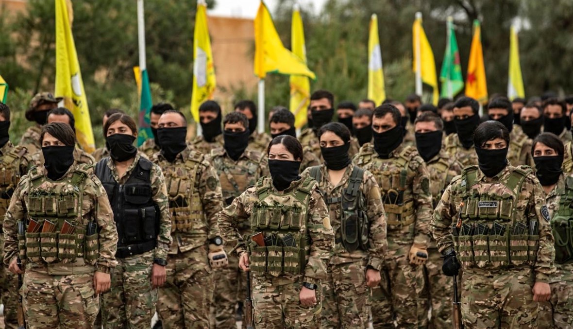 مقاتلون من قوات سوريا الديمقراطية يشاركون في عرض عسكري في حقل العمر النفطي في محافظة دير الزور الشرقية (23 آذار 2021، أ ف ب). 