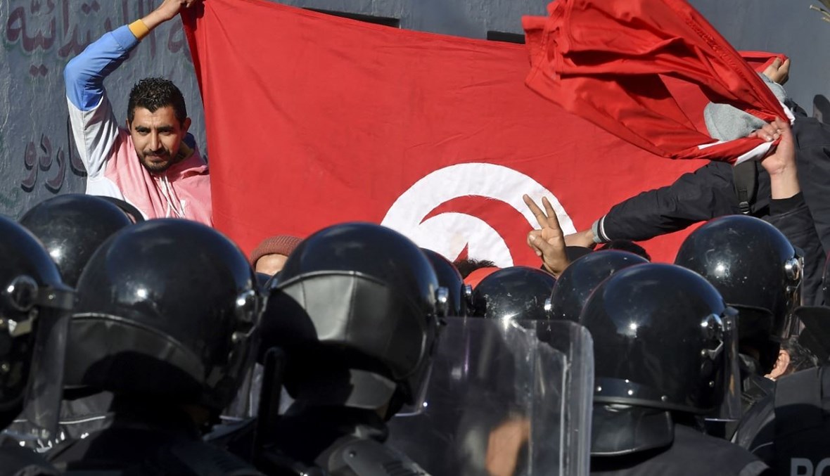 الشرطة التونسية تمنع متظاهرين من الوصول إلى مبنى البرلمان في تونس (26 ك2 2021، أ ف ب). 