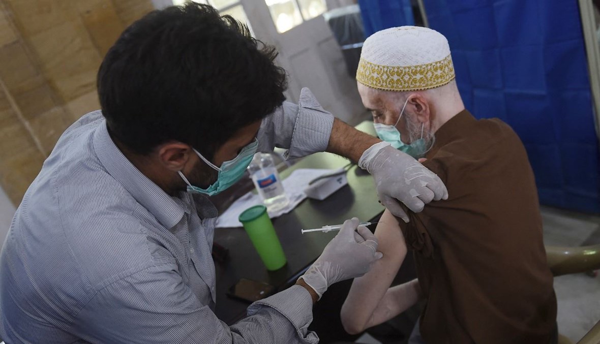 رجل مسن يتلقى لقاح كورونا في مركز تطعيم في كراتشي (26 آذار 2021، أ ف ب). 