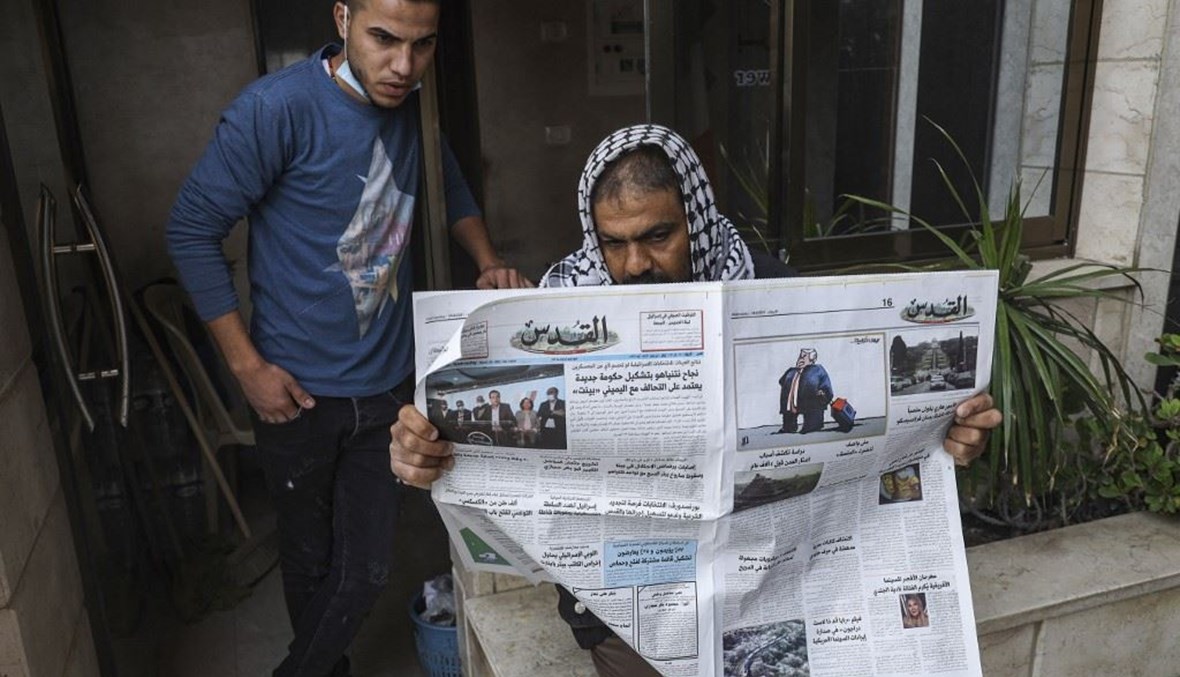 فلسطيني في مدينة غزة يقرأ صحيفة "القدس" الفلسطينية التي نشرت في صفحتها الأولى نتائج الانتخابات الإسرائيلية.   (أ ف ب)