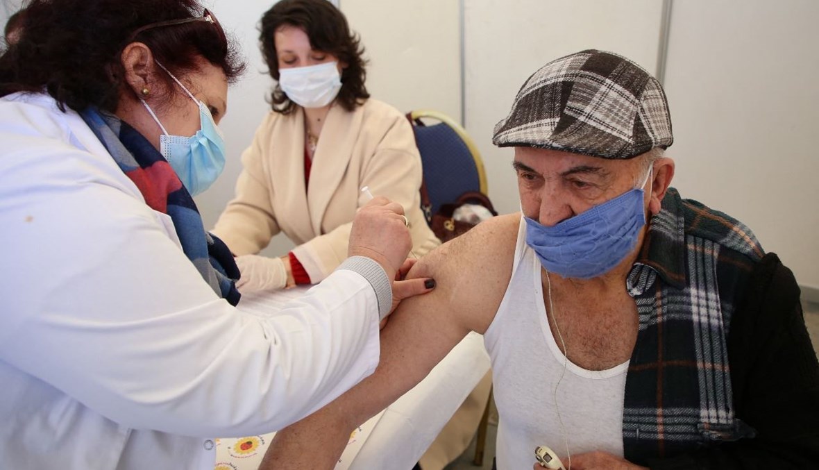 رجل يتلقى لقاح كورونا في خيمة للتطعيم اقيمت في الساحة الرئيسية في تيرانا (28 آذار 2021، أ ف ب). 