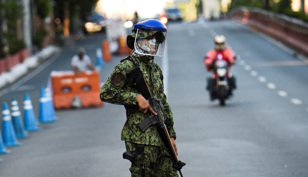 شرطي وقف عند نقطة تفتيش في مانيلا، بعد فرض تدابير صحية مشددة في مواجهة كورونا (25 آذار 2021، أ ف ب). 