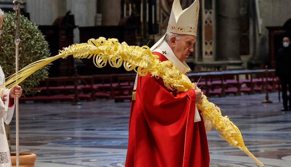 البابا فرنسيس يحمل غصن نخيل لدى وصوله للاحتفال بقداس أحد الشعانين في كاتدرائية القديس بطرس في الفاتيكان (28 آذار 2021، أ ف ب). 