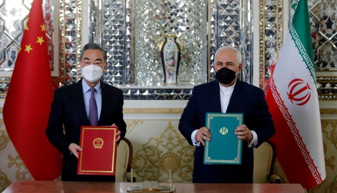 وزير الخارجية الإيرانية محمد جواد ظريف - إلى اليمين- مع نظيره الصيني وانغ يي بعد توقيع الاتفاق في طهران السبت.(أ ف ب)