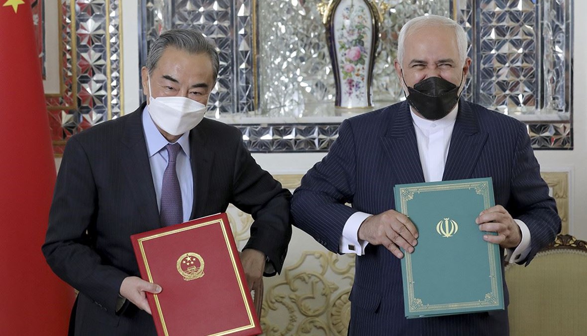 وزيرا الخارجية الصيني وانغ يي والإيراني محمد جواد ظريف يوقعان اتفاق تعاون استراتيجي طويل المدى، 27 آذار 2021 - "أ ب".