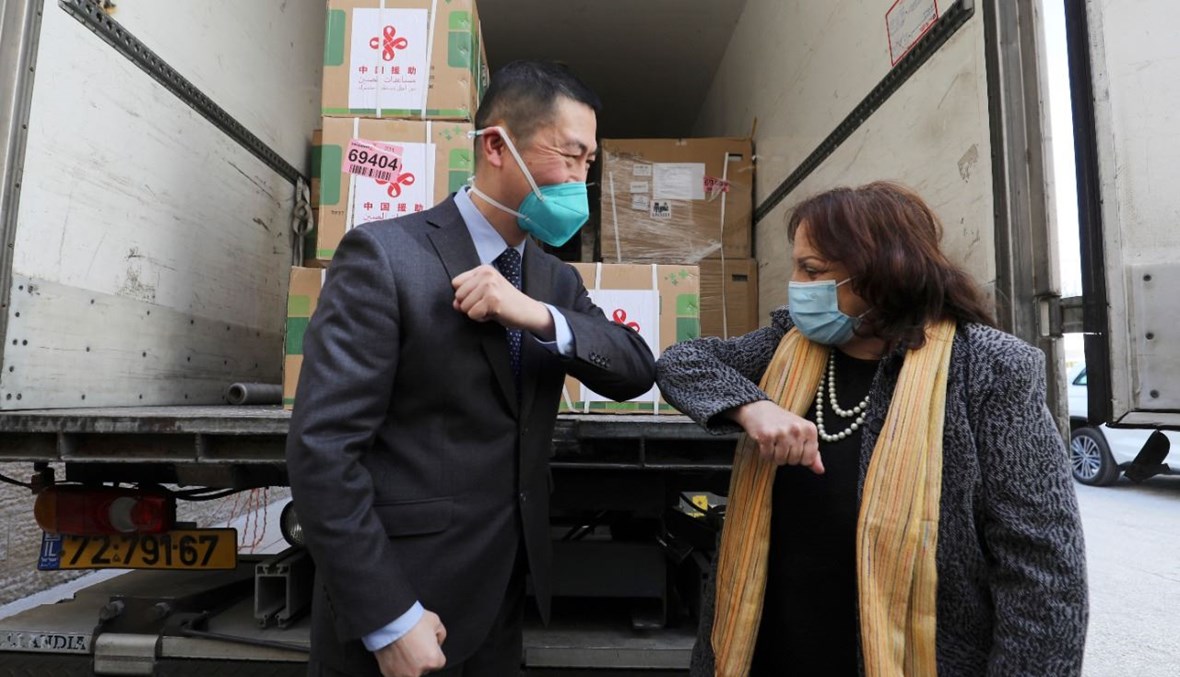 كيلة والسفير الصيني خلال تسلّم اللقاحات في رام الله بالضفة الغربية (29 آذار 2021، أ ف ب).   