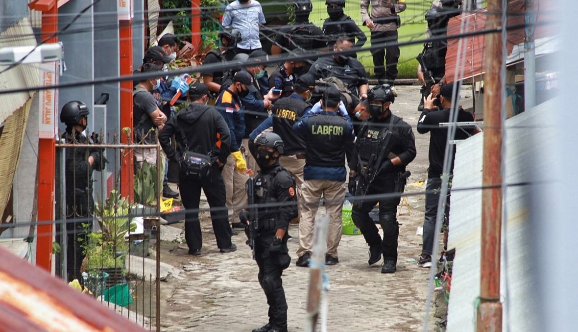 عناصر من الشرطة الإندونيسية يدهمون منزل المشتبه في تنفيذهما تفجير الكاتدرائية في ماكاسار (29 آذار 2021، ا ف ب). 