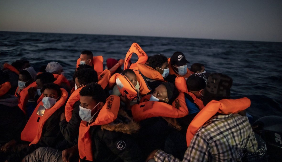 لاجئون على متن قارب مطاطي مكتظ خلال انتظارهم المساعدة من عمال الإغاثة في البحر الأبيض المتوسط (أ ب، 25 شباط 2021). 
