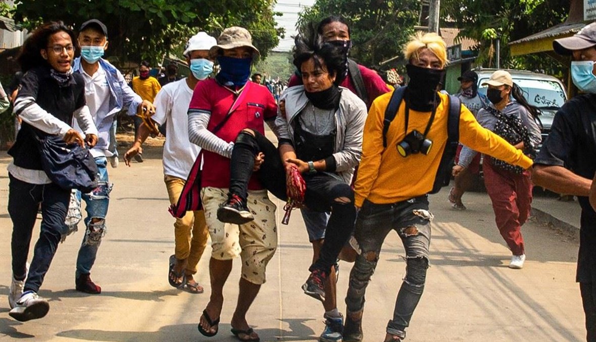 محتجون في رانغون يحملون زميلاً لهم أصيب برصاص قوى الأمن أمس.(أ ف ب)
