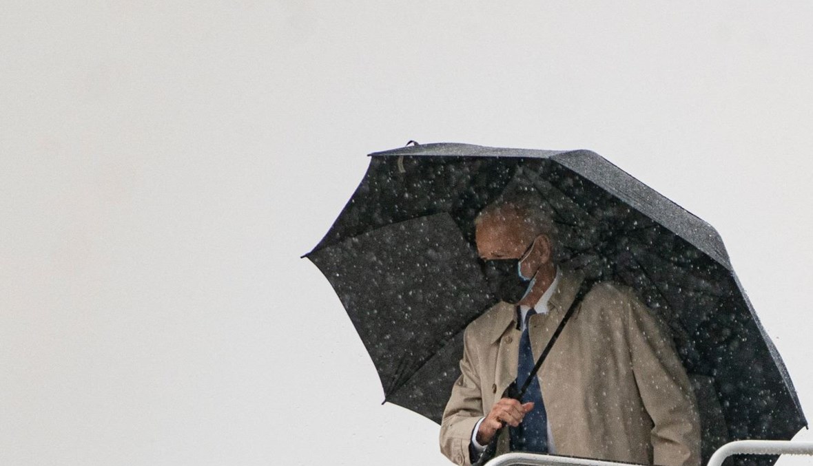 بايدن تحت المطر قبل دخوله الى الطائرة الرئاسية في قاعدة أندروز الجوية في ماريلاند (31 آذار 2021، أ ف ب). 