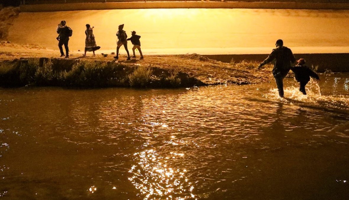 مهاجرون هايتيون يعبرون نهر ريو برافو بشكل غير قانوني في محاولة للوصول من سيوداد خواريز، في ولاية تشيهواهوا المكسيكية، إلى إل باسو في ولاية تكساس الأميركية (30 آذار 2021، أ  ف ب). 