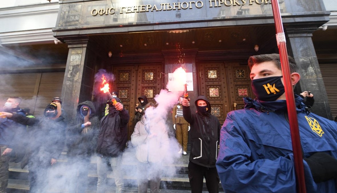 نشطاء من اليمين المتطرف خلال تجمع امام مكتب المدعي العام في وسط كييف، للمطالبة بمعاقبة النائب الموالي لروسيا وحليف بوتين فيكتور ميدفيدشوك بتهمة الخيانة المزعومة (25 آذار 2021، أ ف ب). 