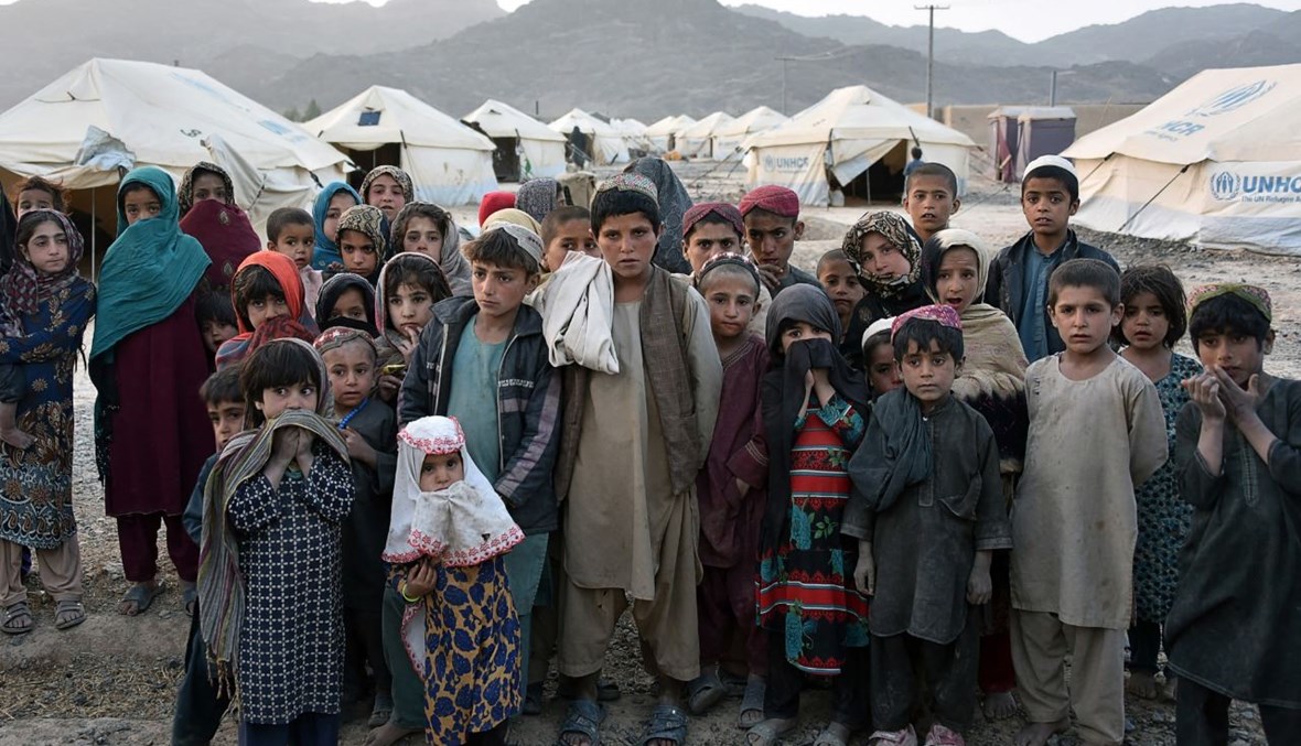أطفال يقفون لالتقاط صورة فوتوغرافية لهم في مخيم للعائلات النازحة في منطقة بانجواي بمقاطعة قندهار (31 آذار 2021، أ ف ب). 