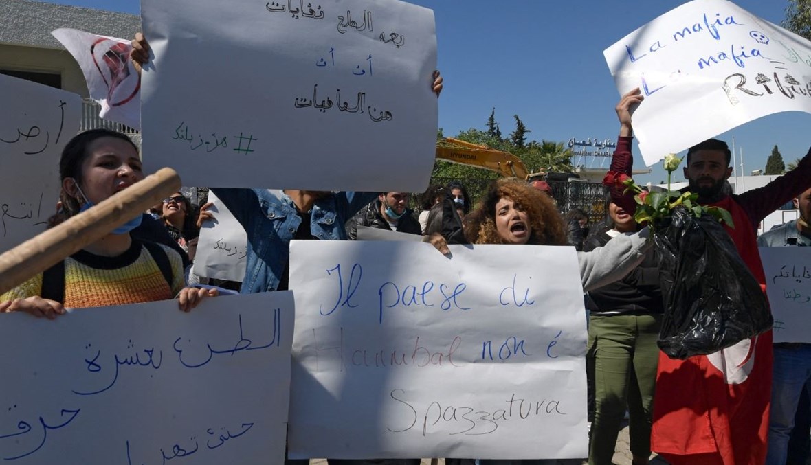 ناشطون بيئيون تونسيون يرددون هتافات خلال تجمعهم أمام مقر السفارة الإيطالية في العاصمة تونس (1 نيسان 2021، ا ف ب).  