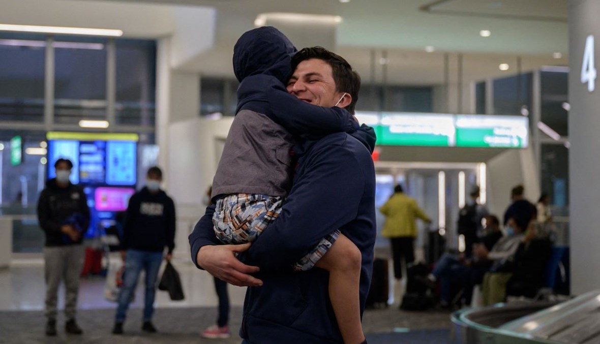 صموئيل يعانق نجله دانيال من هندوراس في مطار لاغوارديا في نيويورك بعد انفصالهما لأشهر (30 آذار 2021، أ ف ب). 