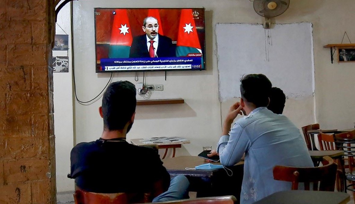 أردنيون في مقهى بعمان يتابعون على شاشة التلفزيون المؤتمر الصحافي لنائب رئيس الوزراء وزير الخارجية أيمن الصفدي الأحد. (أ ف ب) 