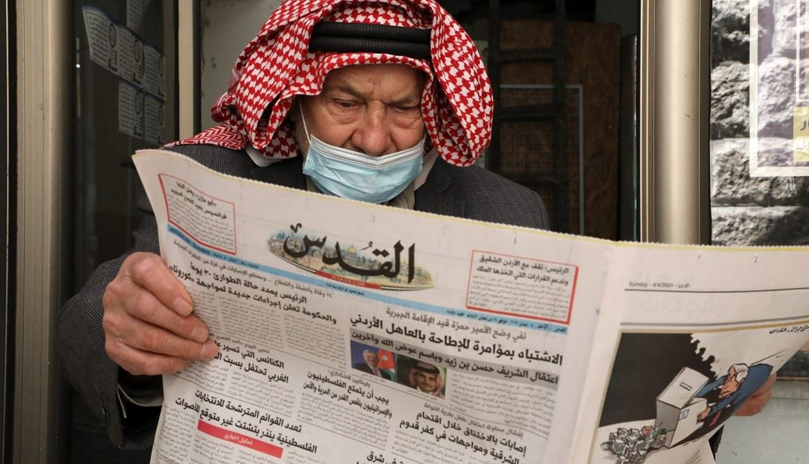 رجل فلسطيني مسنّ يقرأ صحيفة "القدس" التي أوردت في صفحتها الأولى خبراً حول الأحداث الأخيرة في الأردن (أ ف ب).