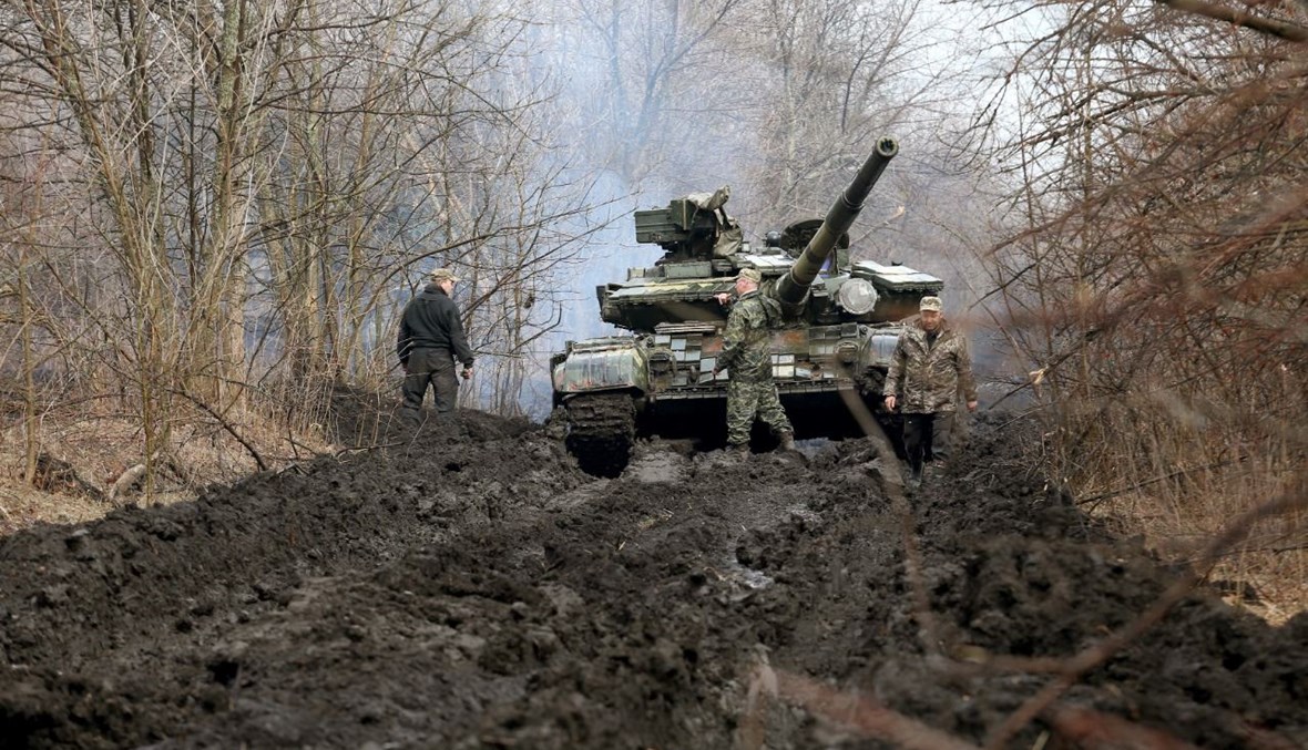جنود أوكرانيون يقفون بالقرب من دبابتهم عند خط المواجهة مع الانفصاليين بالقرب من ليسيتشانسك بمنطقة لوغانسك (7 نيسان 2021، أ ف ب). 
