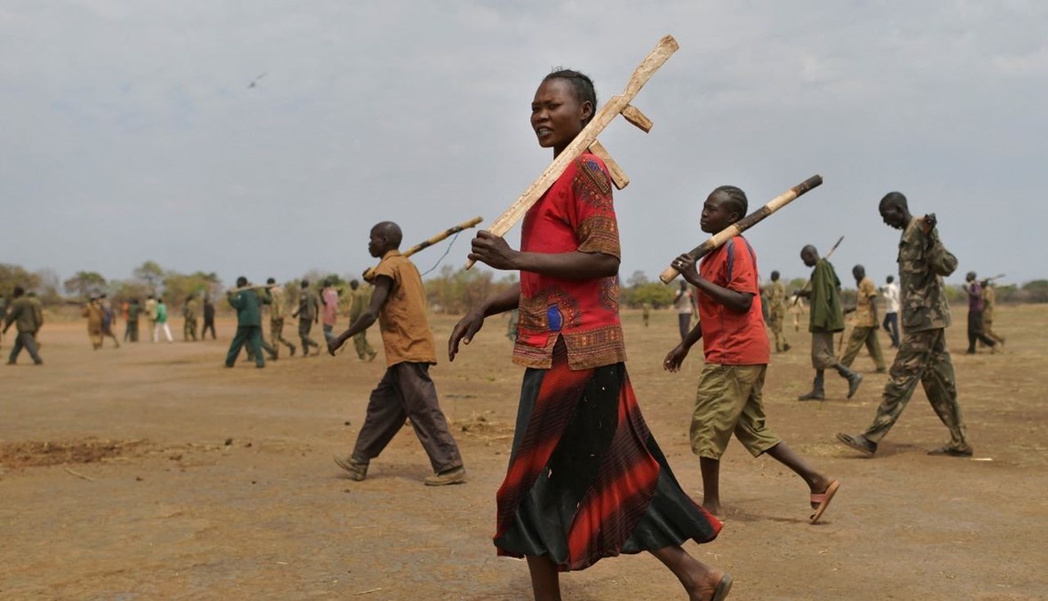جنود متدربون يحملون بنادقهم الخشبية خلال مشاركتهم في برنامج مصالحة تديره الأمم المتحدة في ثكنة موقتة في مابل في جنوب السودان (31 ك2 2020، أ ف ب).