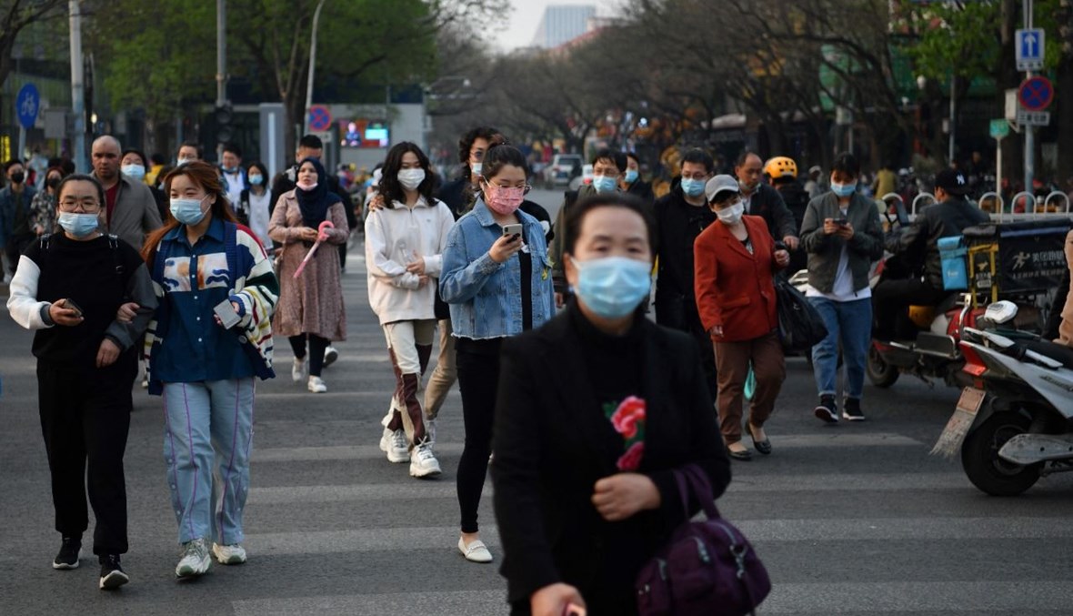 أشخاص يعبرون شارعا في بيجينغ (8 نيسان 2021، ا ف ب).
