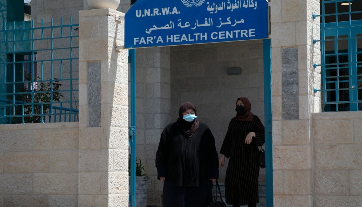 نساء فلسطينيات يخرجن من مركز طبي الأونروا في مخيم الفارعة للاجئين شمال نابلس بالضفة الغربية المحتلة (8 نيسان 2021، أ ف ب). 