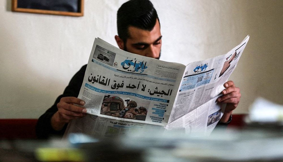 شاب أردني يقرأ صحيفة "الرأي" المحلية التي عنونت على صفحتها الأولى عن الأحداث الأخيرة في بلاده (أ ف ب- 4 نيسان 2021).