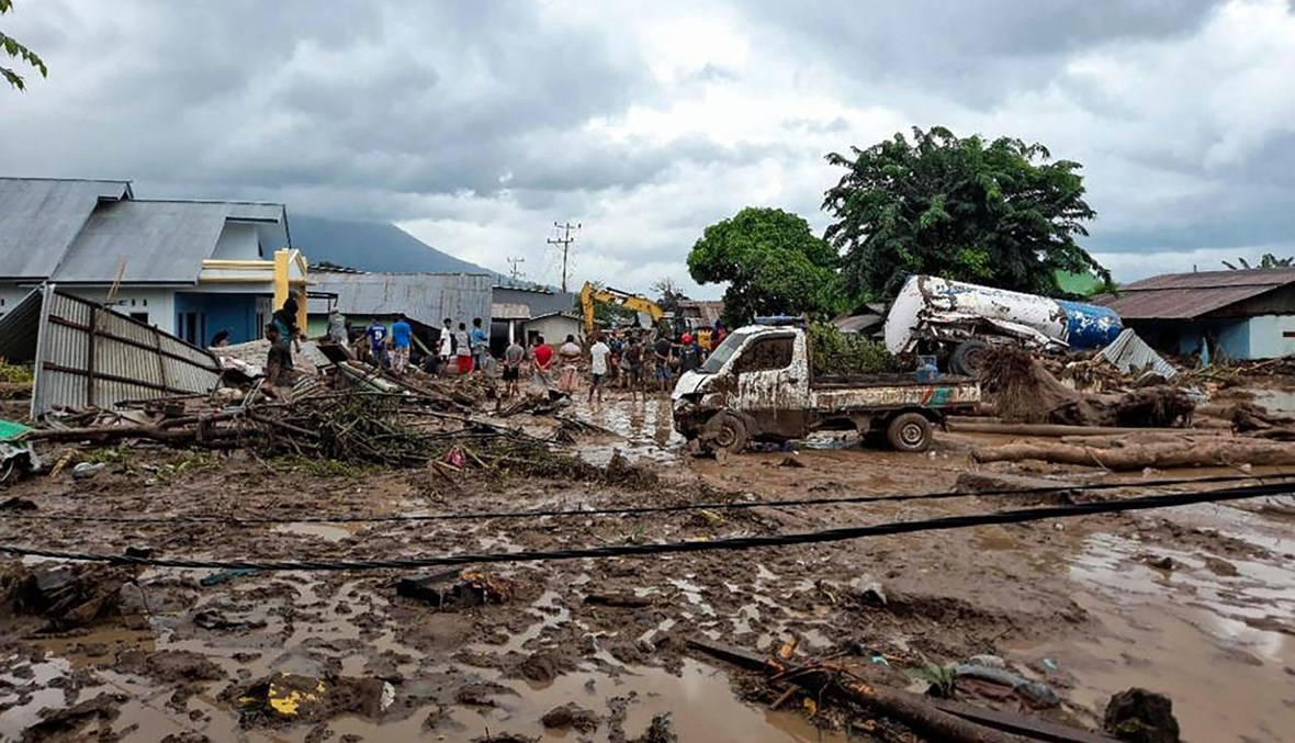 سكان يتفقدون الاضرار في منازلهم في قرية وايويرانغ في ايست فلوريس من جراء اعصار سيروجا (7 نيسان 2021، أ ف ب). 
