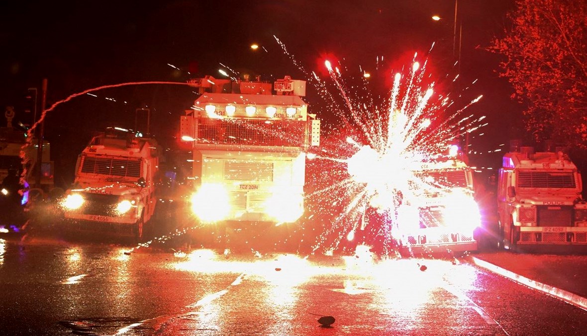 مفرقعات نارية استخدمها محتجون، تنفجر أمام سيارات الشرطة، خلال الاشتباكات في منطقة سبرينغفيلد رود في عاصمة ايرلندا الشمالية، بلفاست (أ ف ب- 8 أبريل 2021).