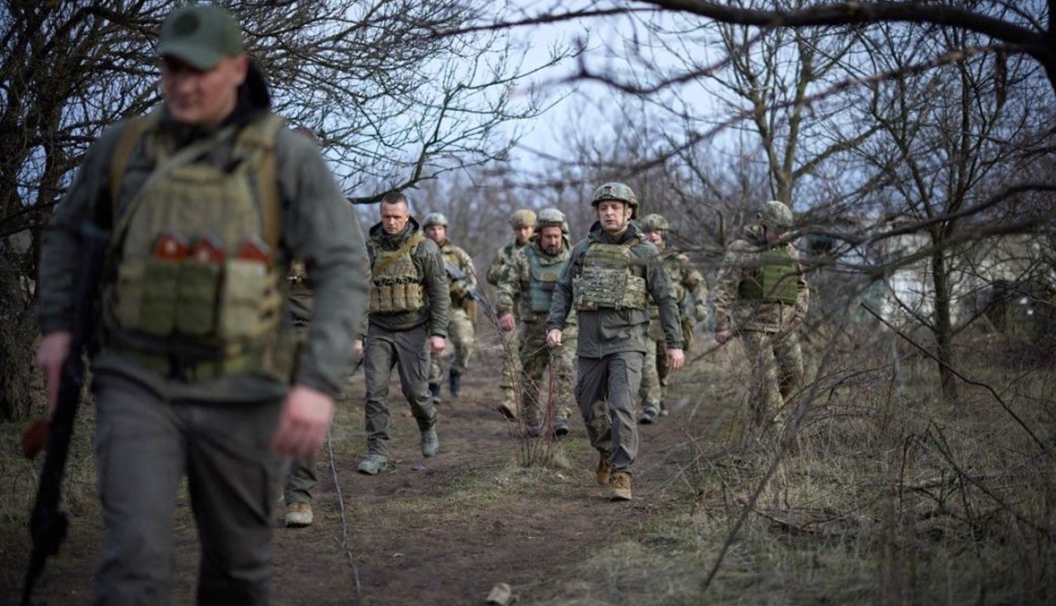 الرئيس الأوكراني فولوديمير زيلينسكي (في الوسط) على خط المواجهة مع الانفصاليين المدعومين من روسيا في منطقة ماريوبول (9 نيسان 2021، ا ف ب).  