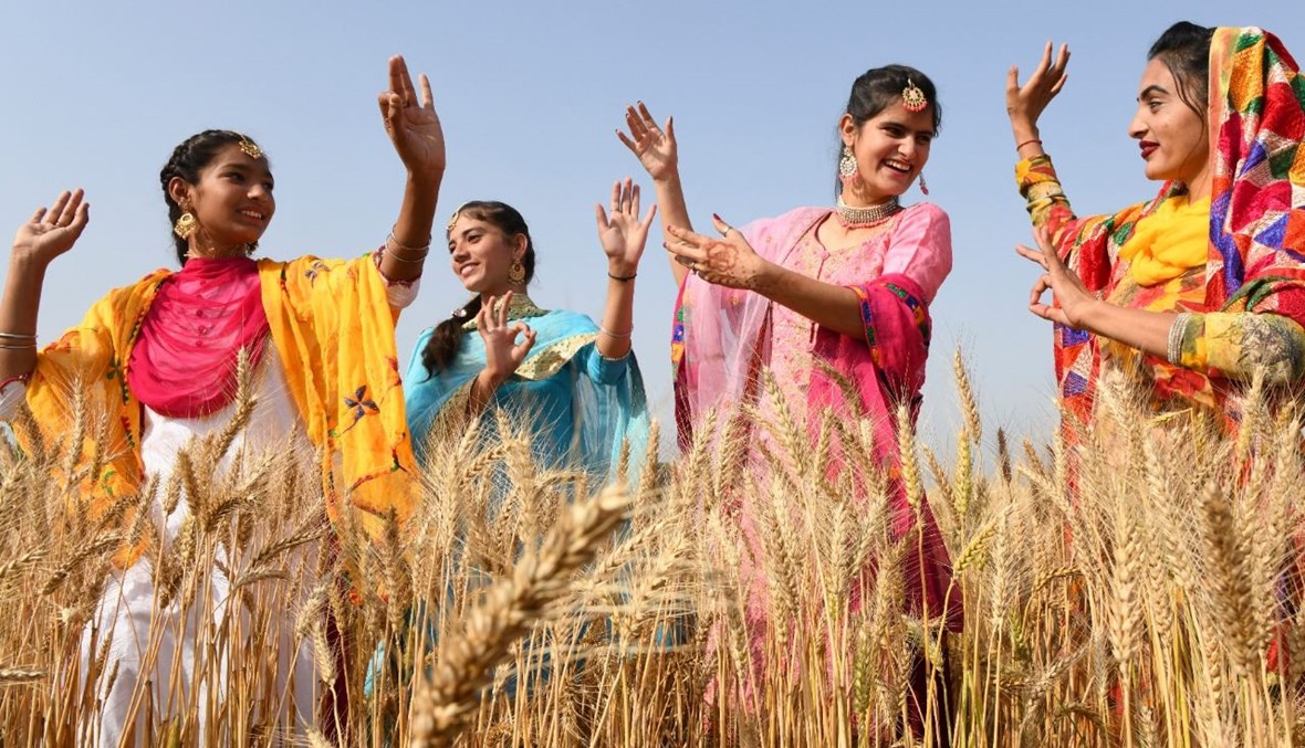 شابات من السيخ يؤدين رقصة شعبية في حقل قمح في ضواحي أمريتسار بالهند، قبل مهرجان الحصاد في بايساخي (11 نيسان 2021، أ ف ب). 