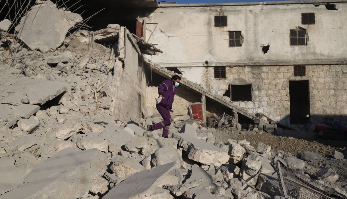 رجل سوري يمشي وسط أنقاض مبنى مدمر في أعقاب غارات جوية روسية على أطراف مدينة إدلب الشمالية الغربية (29 آذار 2021، ا ف ب). 